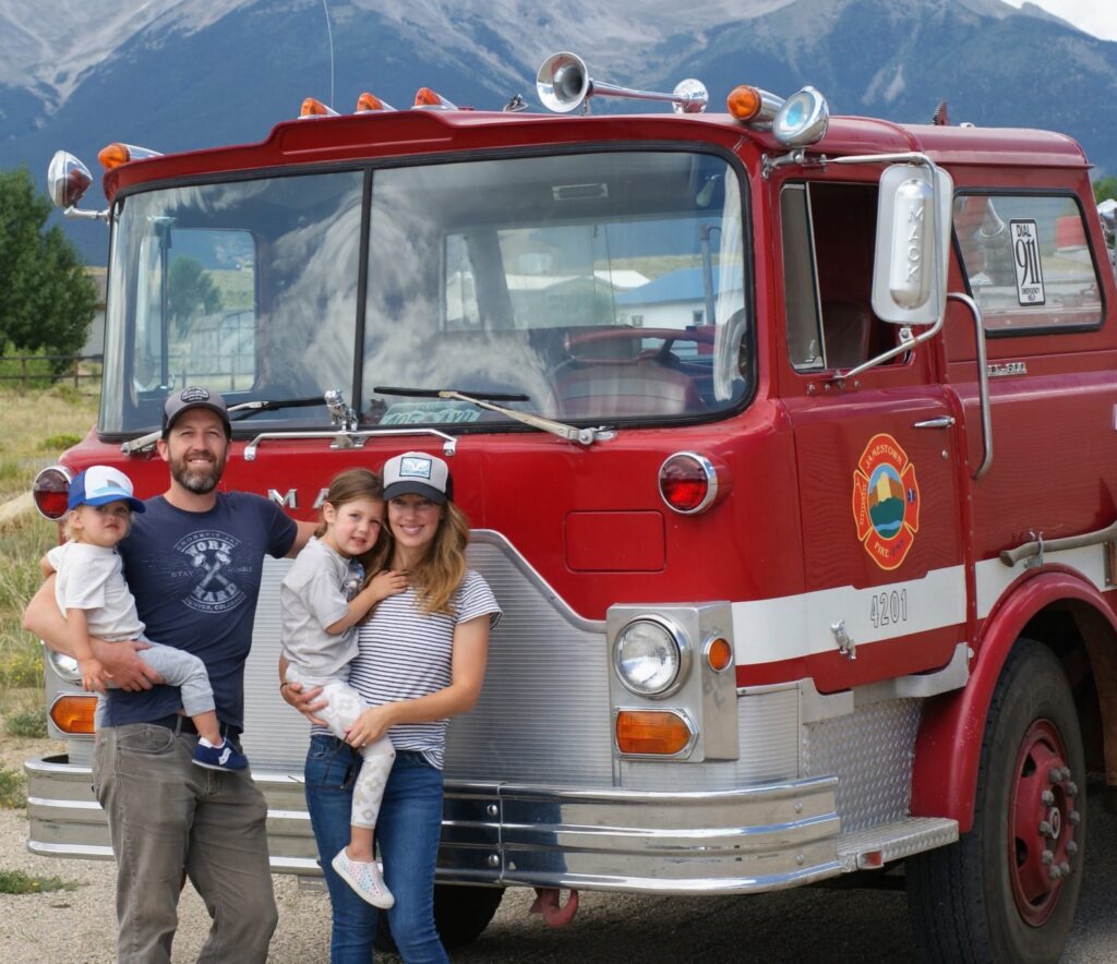 Lead attorney Luke McFarland with his family beside the vintage Mack fire truck gifted to the firm by the City of Jamestown, Colorado.